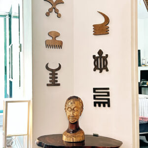 Wooden Ghanaian Adinkra symbols displayed as wall decor